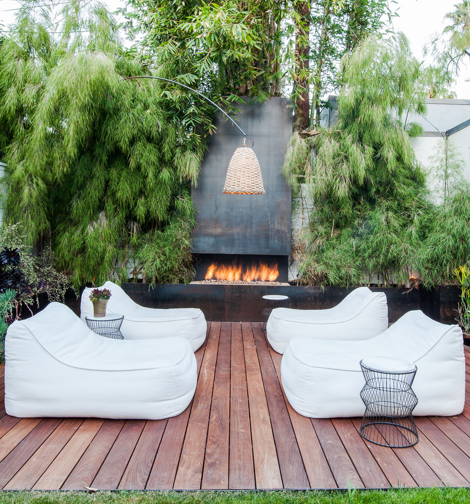 This is an example of a mid-sized contemporary backyard deck in Austin with a fire feature.