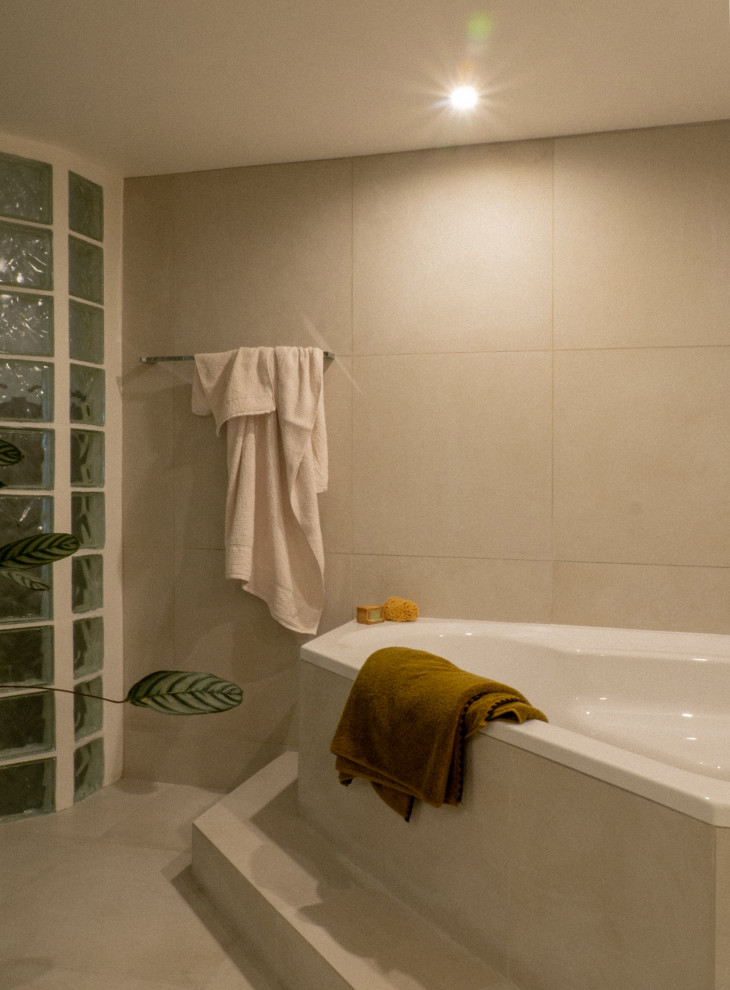 Aménagement d'une grande salle de bain principale et grise et blanche contemporaine avec une baignoire d'angle, un carrelage gris, un mur gris et un sol gris.