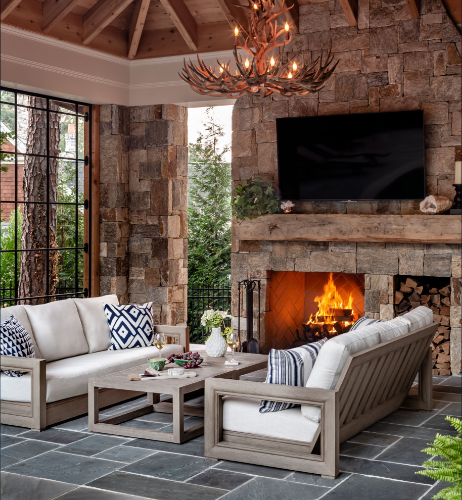 Foto de patio clásico en anexo de casas con chimenea y suelo de baldosas