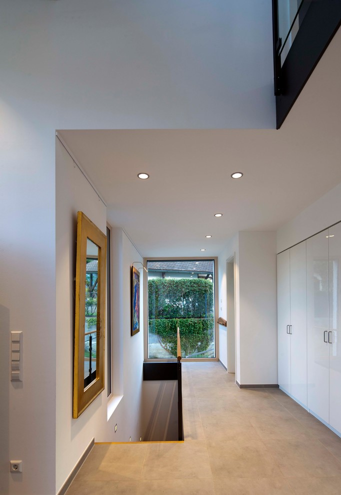 Photo of a mid-sized contemporary hallway in Munich with white walls and grey floor.
