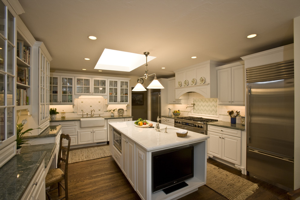 Photo of a traditional l-shaped separate kitchen in San Francisco with glass-front cabinets, stainless steel appliances, a farmhouse sink, white cabinets and multi-coloured splashback.