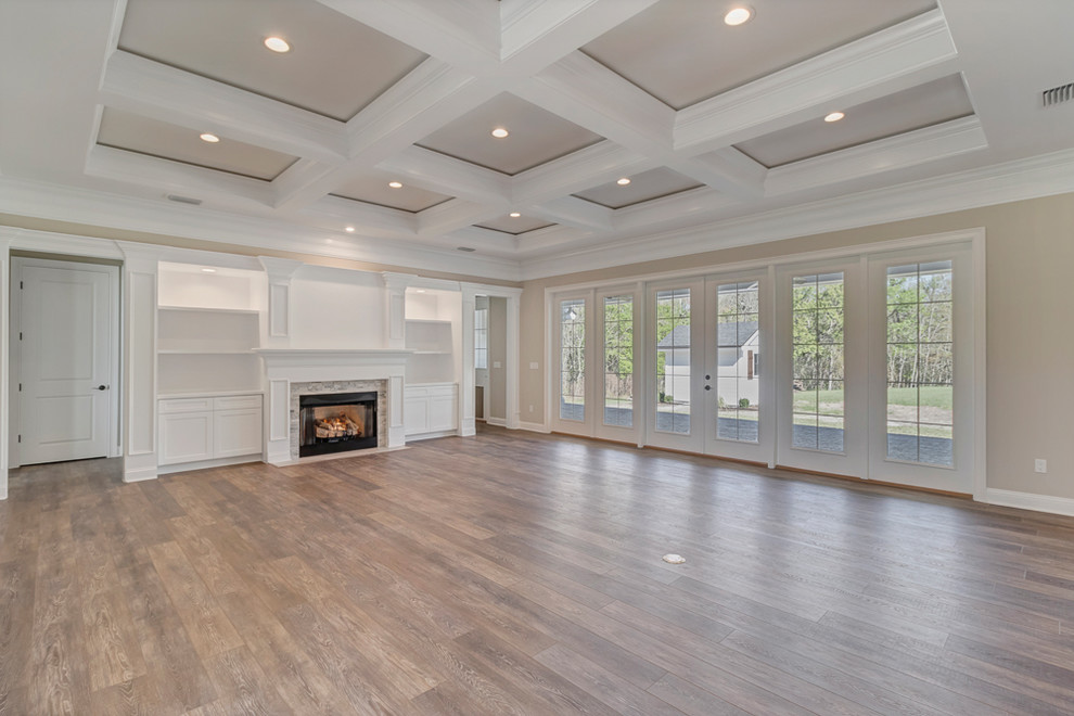 Inspiration for a large cottage enclosed vinyl floor and brown floor family room remodel in Jacksonville with gray walls, a standard fireplace and a stone fireplace