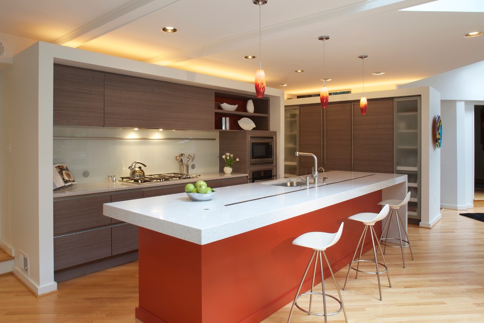 Photo of a modern l-shaped kitchen in DC Metro with an undermount sink, flat-panel cabinets, glass sheet splashback and panelled appliances.