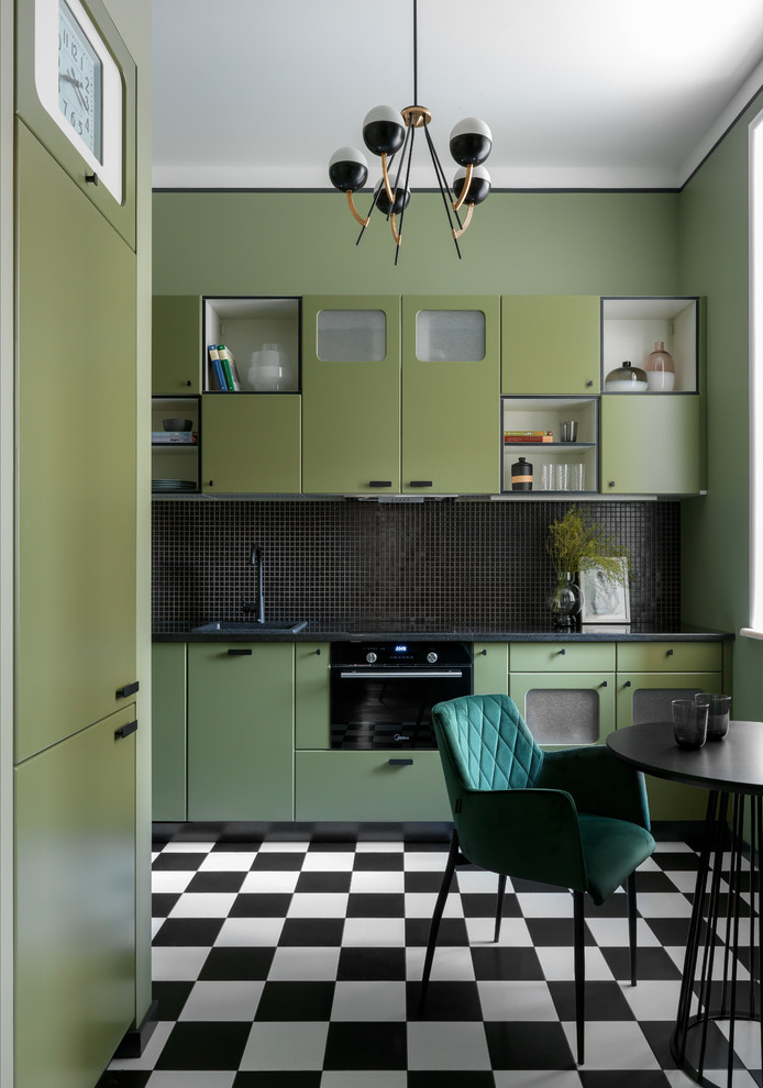 Small eclectic separate kitchen in Moscow with flat-panel cabinets, green cabinets, granite benchtops, black splashback, mosaic tile splashback, black appliances, porcelain floors, black benchtop, a drop-in sink, no island and multi-coloured floor.