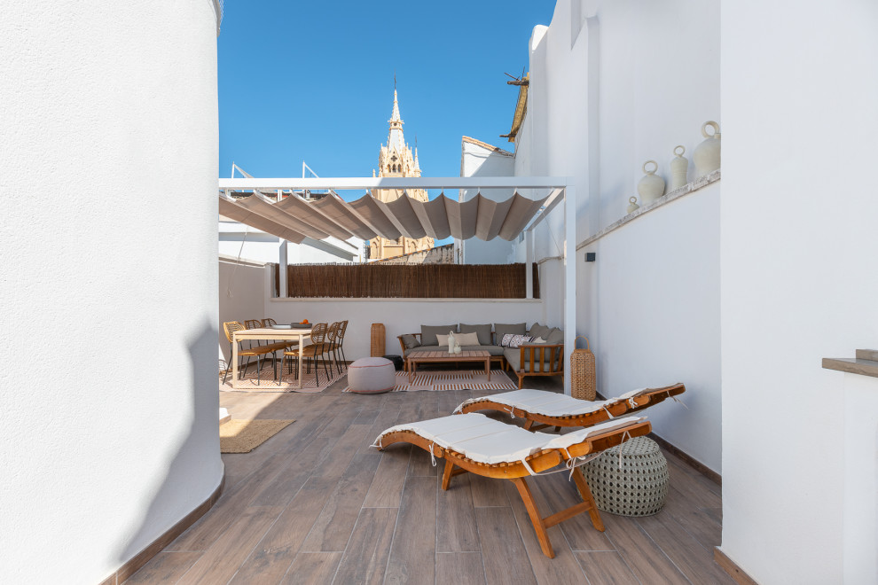 This is an example of a large transitional rooftop and first floor deck in Malaga.