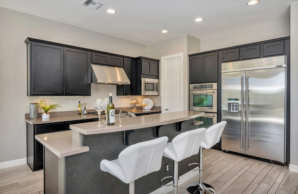 Mid-sized transitional galley ceramic tile and gray floor kitchen pantry photo in Phoenix with an undermount sink, quartz countertops, stainless steel appliances and an island