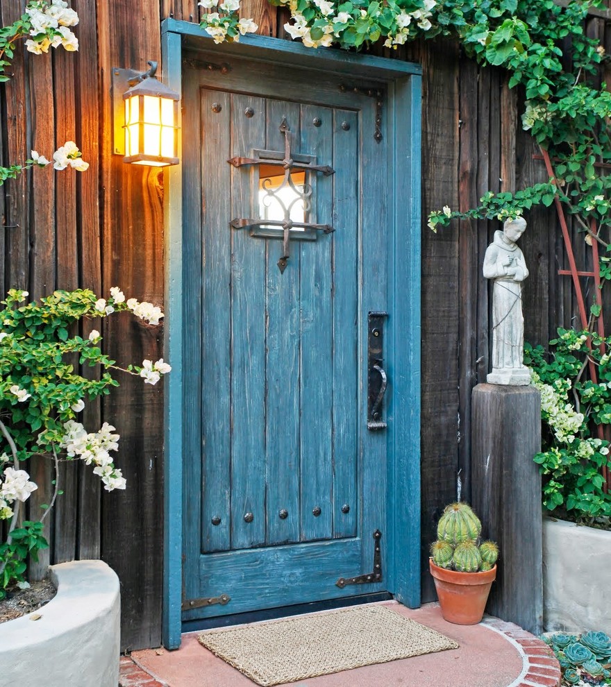 Country entryway in Santa Barbara with a single front door and a blue front door.