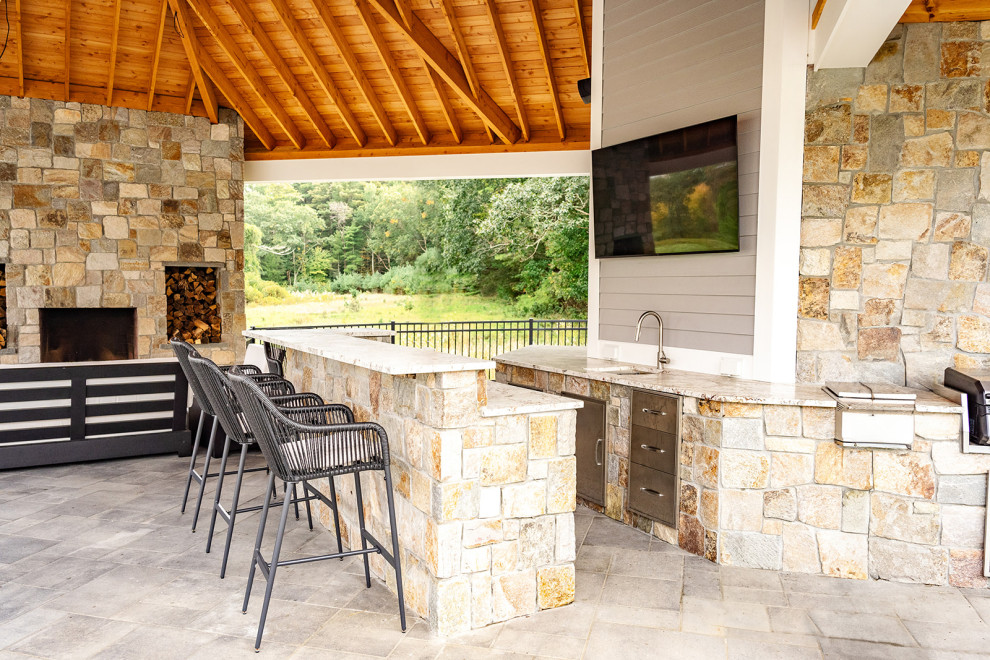 Inspiration for a large contemporary backyard patio in Boston with an outdoor kitchen and natural stone pavers.
