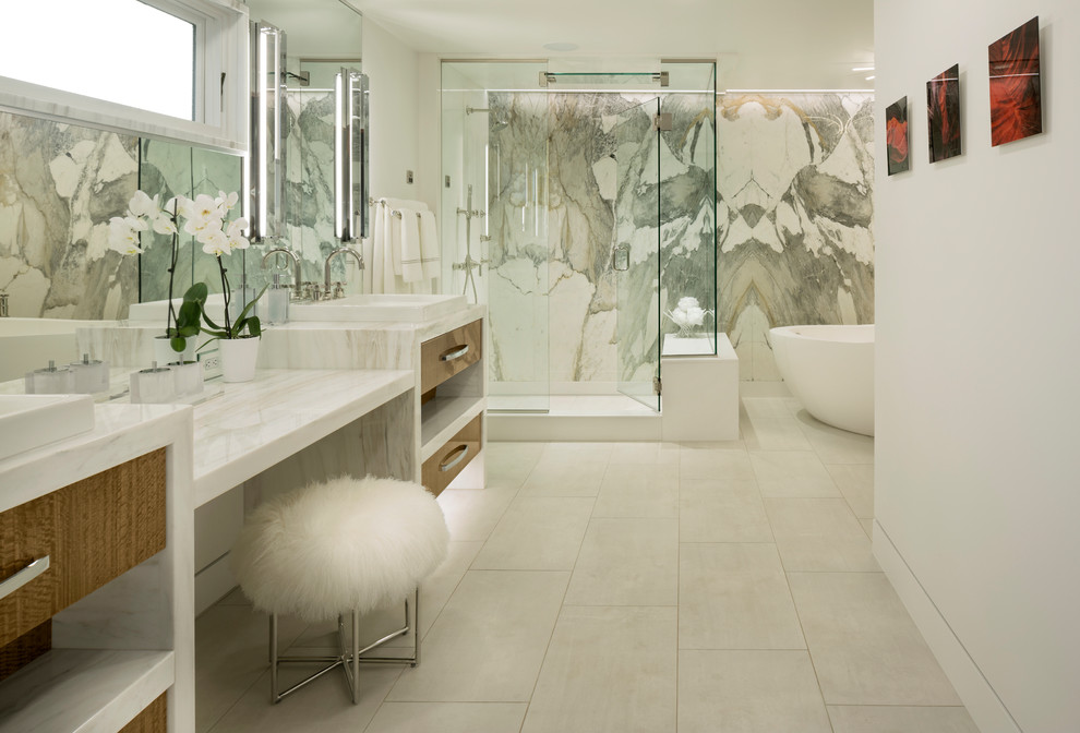 Photo of a large contemporary master bathroom in Other with flat-panel cabinets, light wood cabinets, a freestanding tub, a corner shower, multi-coloured tile, stone slab, white walls, porcelain floors, a vessel sink, marble benchtops, white floor, a hinged shower door and white benchtops.