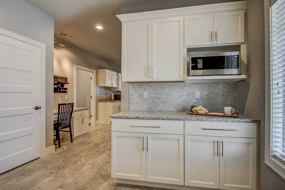 Inspiration for a large transitional home design remodel with an undermount sink, shaker cabinets, yellow cabinets, granite countertops, gray walls and a side-by-side washer/dryer