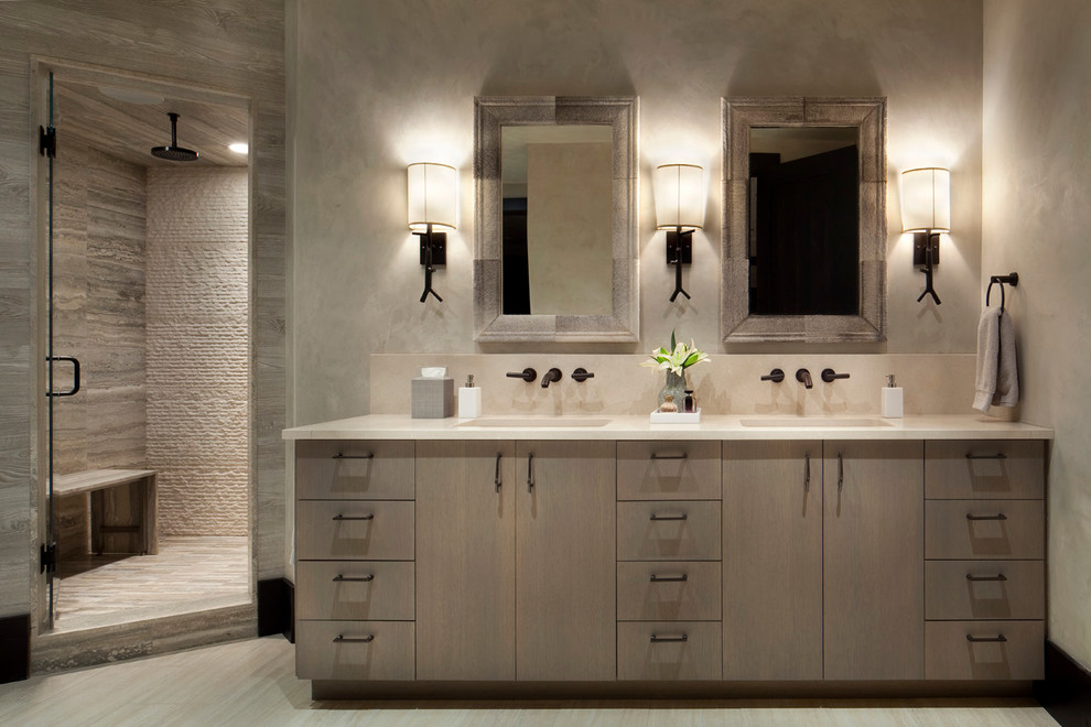 Photo of a country bathroom in Other with an integrated sink, flat-panel cabinets, light wood cabinets, a corner shower, beige tile, beige walls and light hardwood floors.