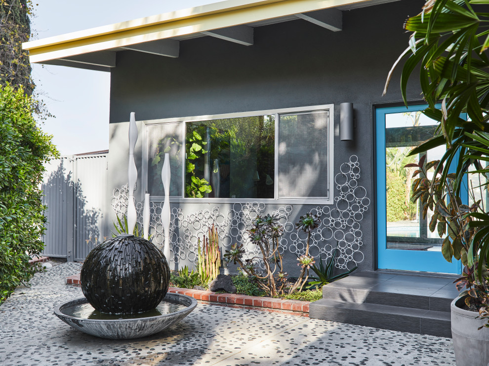 Diseño de fachada de casa gris vintage de tamaño medio de una planta con revestimiento de estuco y tejado plano