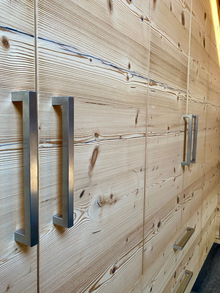 Foto de armario unisex contemporáneo grande con puertas de armario de madera clara y vigas vistas