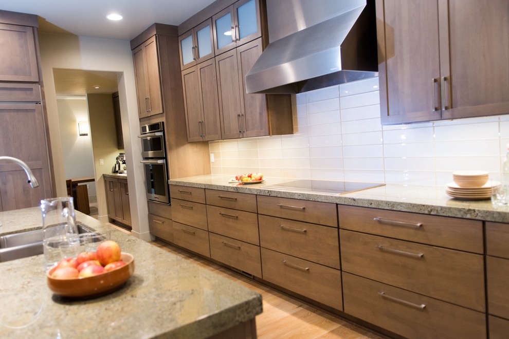 Kitchen - contemporary light wood floor kitchen idea with an undermount sink, shaker cabinets, granite countertops, white backsplash, glass tile backsplash, stainless steel appliances and beige countertops
