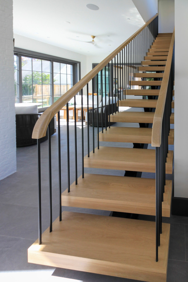 На фото: огромная лестница на больцах в стиле модернизм с деревянными ступенями, перилами из смешанных материалов и стенами из вагонки с