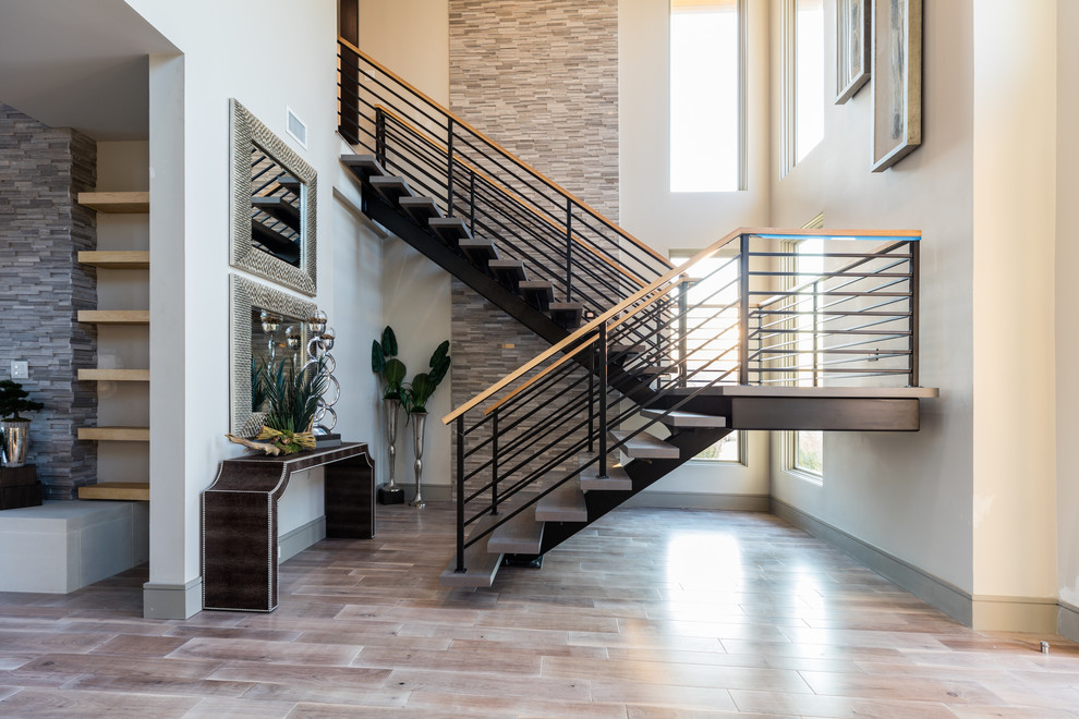 This is an example of an expansive transitional wood u-shaped staircase in Dallas with open risers and cable railing.
