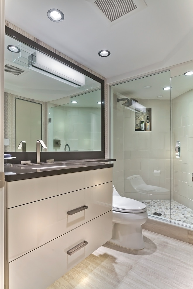 Inspiration for a small transitional 3/4 bathroom in Minneapolis with flat-panel cabinets, beige cabinets, a corner shower, a one-piece toilet, beige tile, ceramic tile, white walls, ceramic floors, an undermount sink and engineered quartz benchtops.