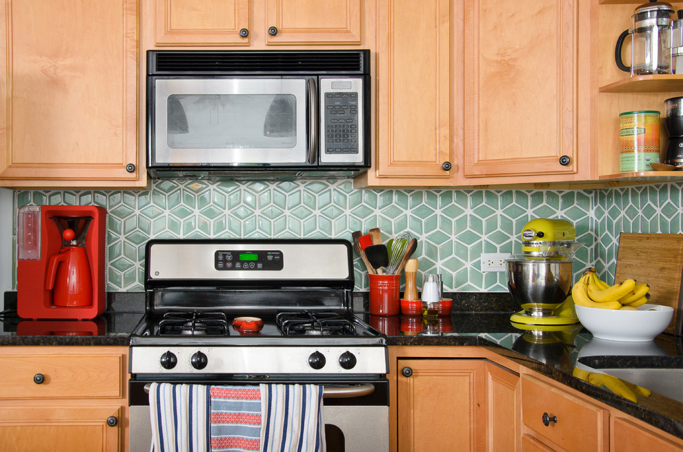 Mid-sized transitional u-shaped medium tone wood floor eat-in kitchen photo in Chicago with an undermount sink, raised-panel cabinets, medium tone wood cabinets, granite countertops, green backsplash, porcelain backsplash, stainless steel appliances and a peninsula