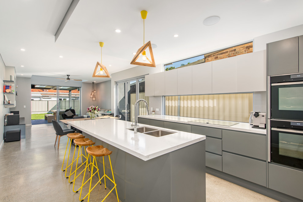 Inspiration for a contemporary kitchen in Sydney with an undermount sink, flat-panel cabinets, grey cabinets, black appliances and with island.