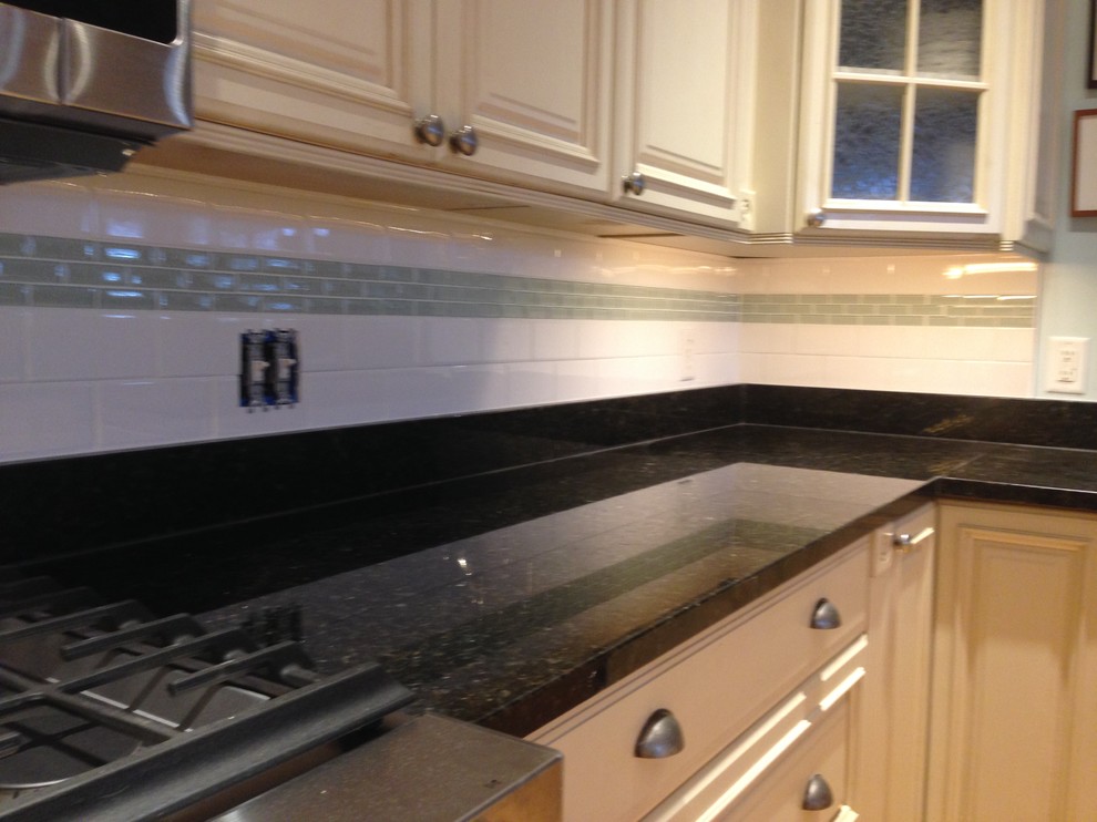 Example of a transitional kitchen design in Chicago with raised-panel cabinets, white cabinets, quartz countertops, white backsplash and porcelain backsplash