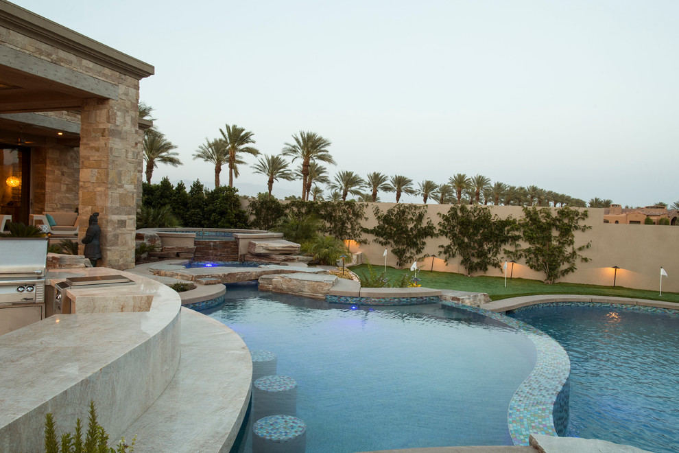 Example of a mid-sized transitional backyard concrete paver and round natural pool fountain design