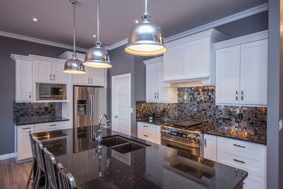 Mid-sized transitional l-shaped porcelain tile eat-in kitchen photo in Calgary with a double-bowl sink, shaker cabinets, white cabinets, multicolored backsplash, mosaic tile backsplash, stainless steel appliances, an island and quartz countertops