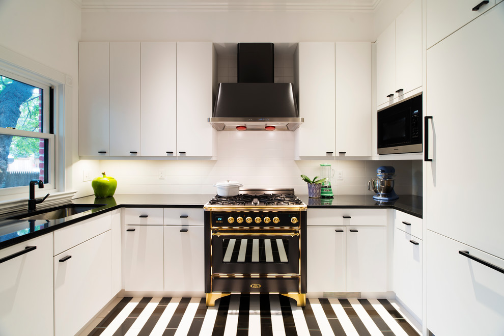 This is an example of a mid-sized contemporary u-shaped separate kitchen in Orange County with a single-bowl sink, flat-panel cabinets, white cabinets, white splashback, black appliances, ceramic splashback, porcelain floors, no island and multi-coloured floor.