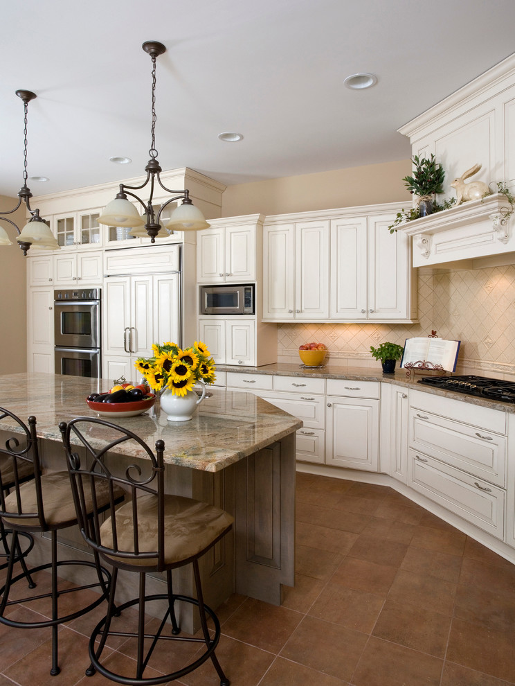 Inspiration for a large traditional l-shaped kitchen in Chicago with an undermount sink, raised-panel cabinets, white cabinets, granite benchtops, beige splashback, ceramic splashback, panelled appliances, ceramic floors and with island.