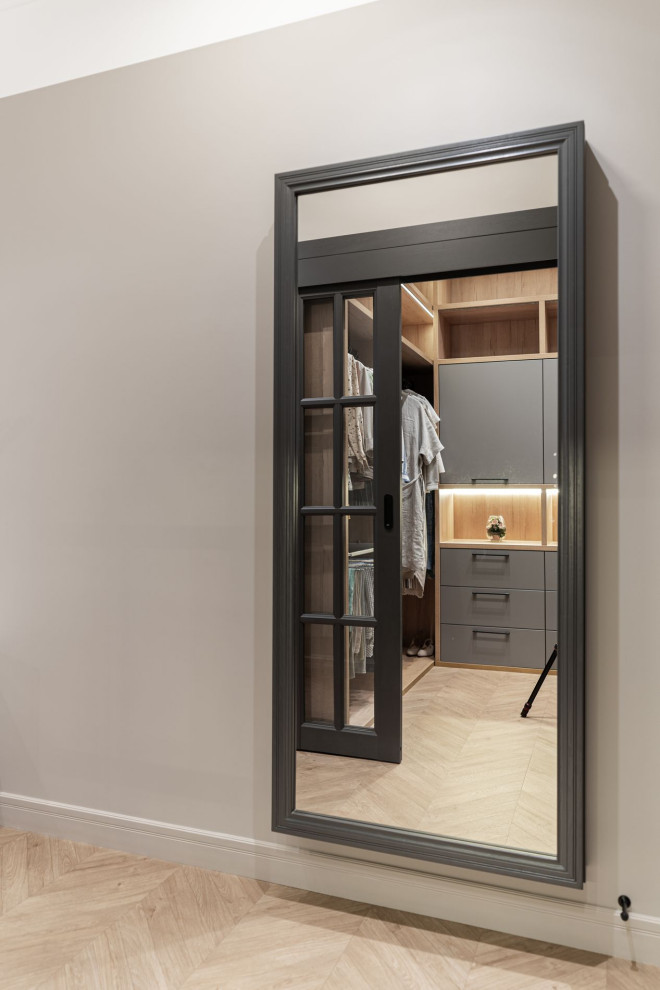 This is an example of a medium sized classic walk-in wardrobe in Other with glass-front cabinets and dark wood cabinets.
