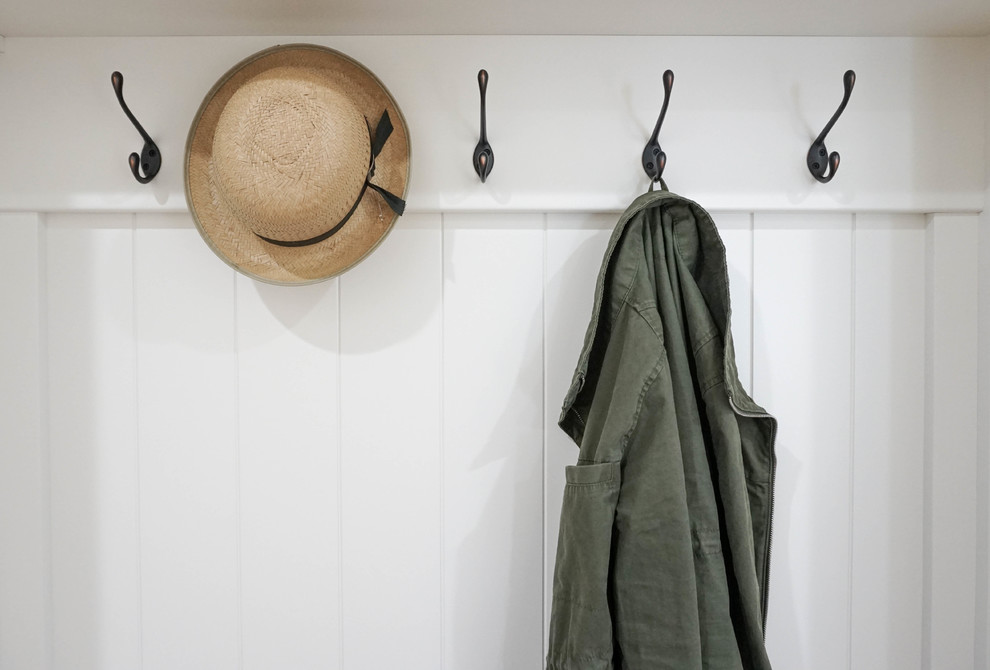 Mid-sized country mudroom in Other with white walls, ceramic floors and brown floor.
