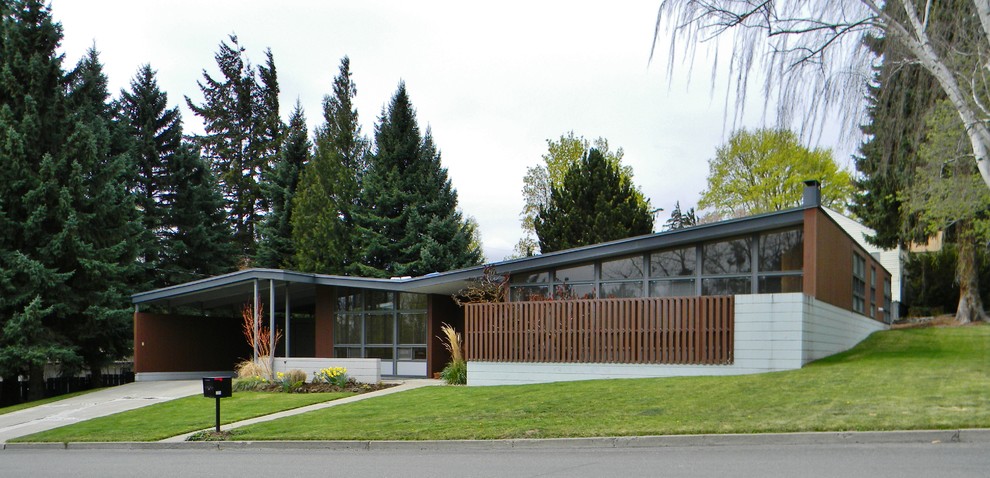 Midcentury concrete exterior in Seattle with a butterfly roof.