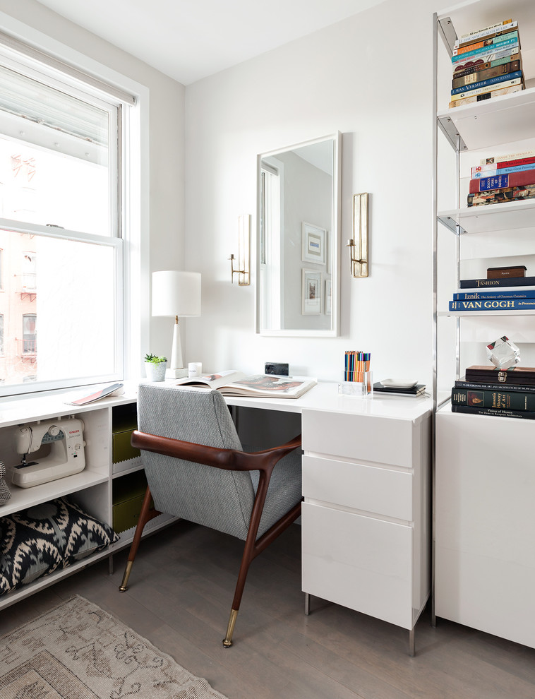 Design ideas for a transitional craft room in New York with white walls, light hardwood floors and a freestanding desk.