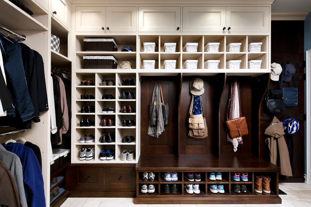 This is an example of a large traditional gender-neutral walk-in wardrobe in Toronto with beige cabinets, open cabinets and travertine floors.