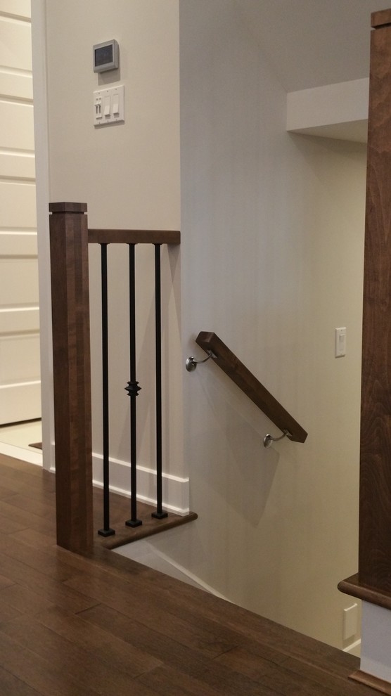 Design ideas for a mid-sized transitional wood u-shaped staircase in Montreal with painted wood risers and wood railing.