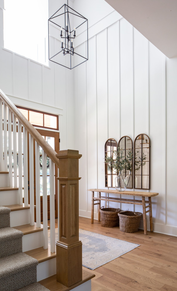 Design ideas for a large country foyer in Houston with white walls, medium hardwood floors, a double front door, a dark wood front door, brown floor and wood walls.