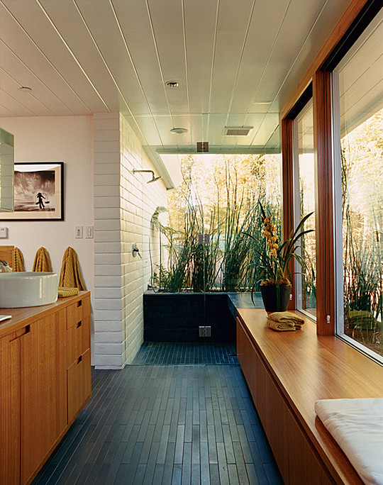 This is an example of a mid-sized midcentury master bathroom in San Francisco with flat-panel cabinets, medium wood cabinets, an open shower, white walls, a vessel sink, wood benchtops, black floor, an open shower, white tile, ceramic tile and slate floors.