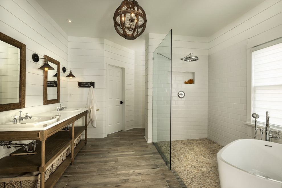 This is an example of a large arts and crafts master bathroom in Atlanta with open cabinets, light wood cabinets, a freestanding tub, a curbless shower, multi-coloured tile, mosaic tile, white walls, porcelain floors, a drop-in sink and engineered quartz benchtops.