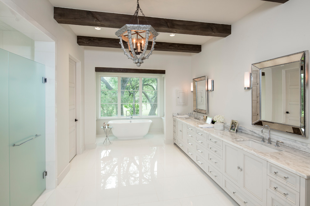 Inspiration for a country master bathroom in Austin with recessed-panel cabinets, grey cabinets, a freestanding tub, a curbless shower, white walls, an undermount sink, white floor, a hinged shower door and grey benchtops.