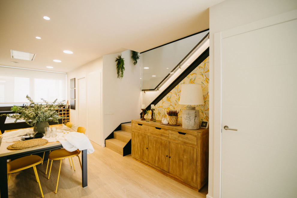 Foto di una sala da pranzo aperta verso il soggiorno contemporanea di medie dimensioni con pareti grigie, pavimento in legno massello medio e nessun camino