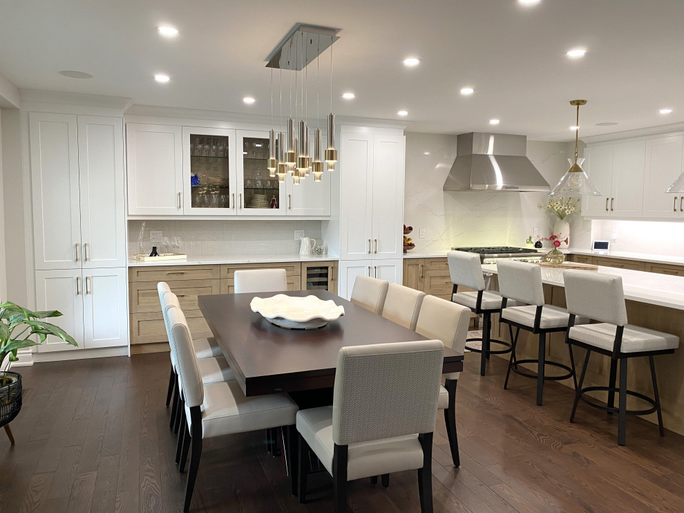 Eat-in kitchen - mid-sized transitional l-shaped medium tone wood floor and brown floor eat-in kitchen idea in Toronto with an undermount sink, shaker cabinets, white cabinets, quartz countertops, white backsplash, quartz backsplash, stainless steel appliances, an island and white countertops