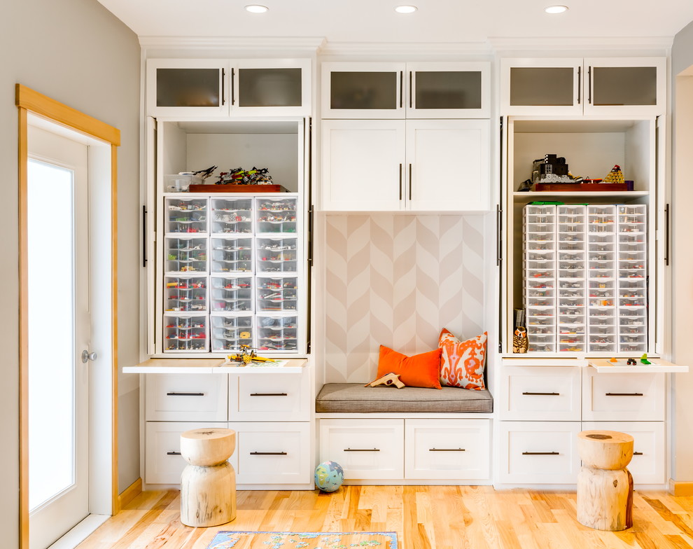 Photo of a transitional gender-neutral kids' playroom in Seattle with light hardwood floors and grey walls.