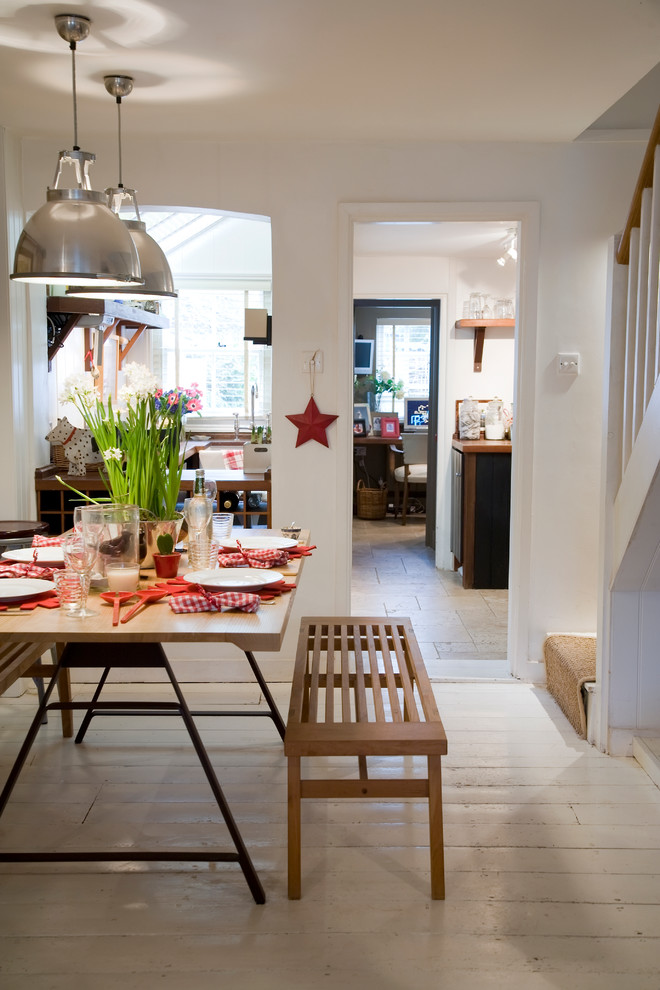 Design ideas for a country dining room in London with white walls and painted wood floors.