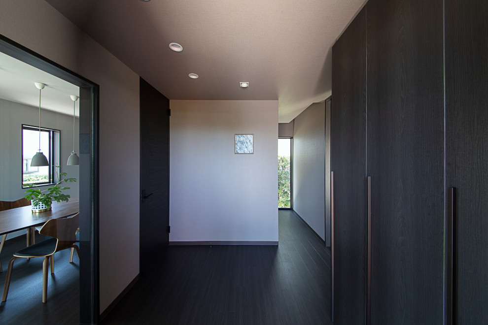 Photo of a mid-sized traditional entry hall in Other with white walls, vinyl floors, a single front door, a black front door, black floor, wallpaper and wallpaper.