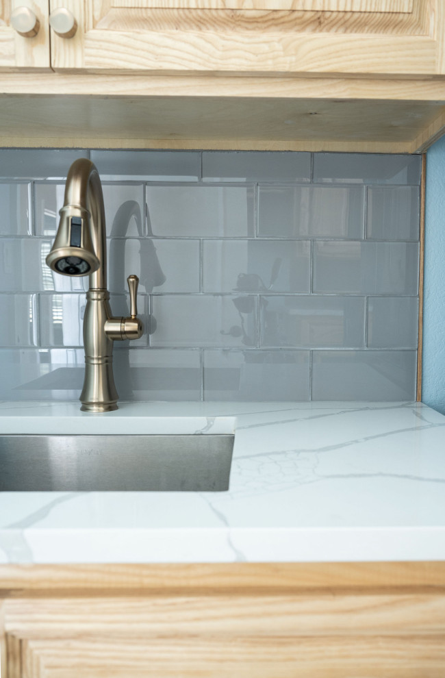 Idéer för parallella vitt tvättstugor enbart för tvätt, med en allbänk, luckor med upphöjd panel, skåp i ljust trä, bänkskiva i kvartsit, blått stänkskydd, stänkskydd i keramik, blå väggar, klinkergolv i keramik, en tvättpelare och flerfärgat golv