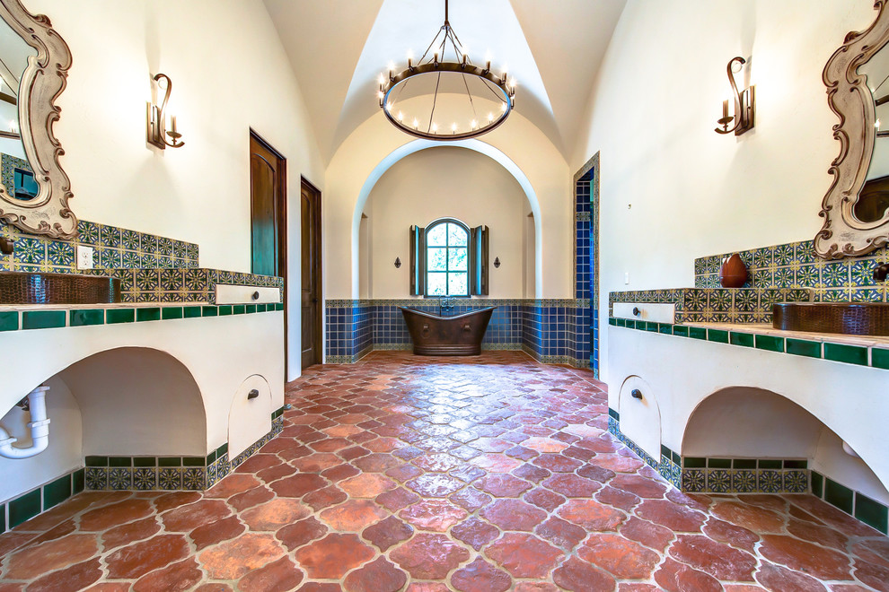 Design ideas for a mid-sized country master bathroom in Austin with a vessel sink, tile benchtops, a freestanding tub, a double shower, green tile, terra-cotta tile, beige walls and terra-cotta floors.