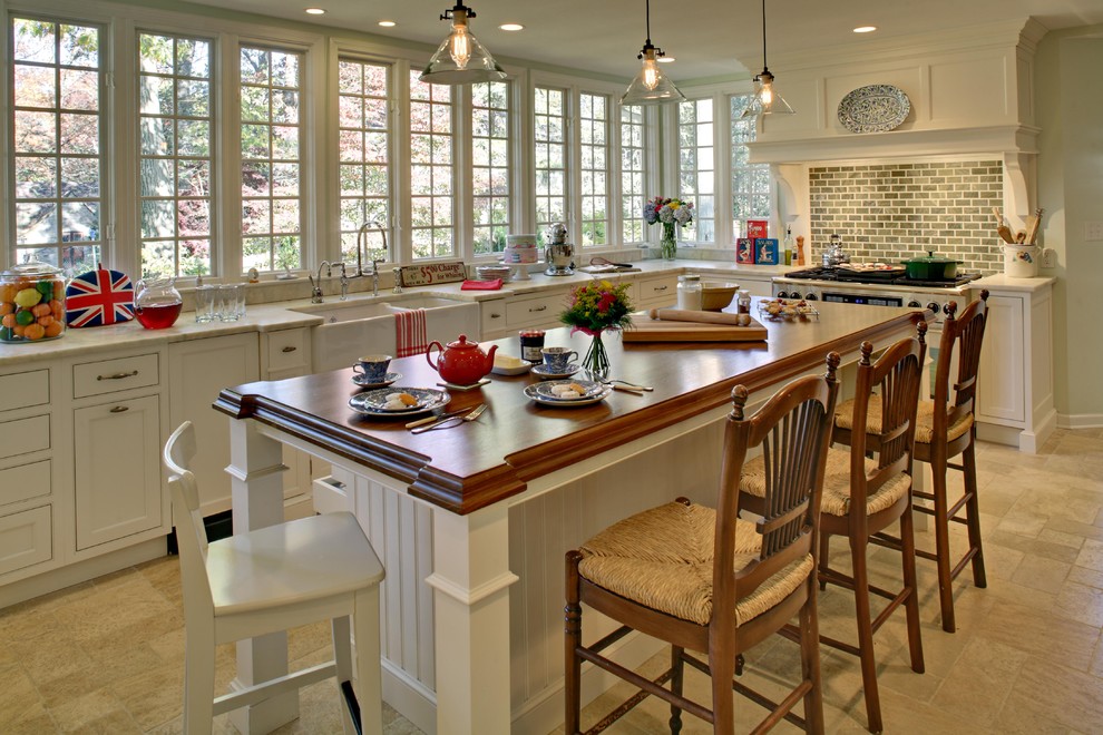 Traditional kitchen in Newark with a farmhouse sink, wood benchtops, white cabinets, recessed-panel cabinets and with island.