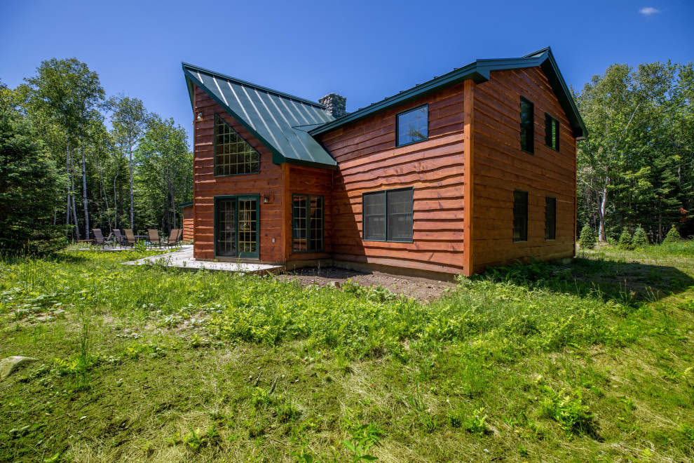 Ejemplo de fachada de casa marrón rústica de dos plantas con revestimiento de madera, tejado de metal, tablilla y tejado a dos aguas