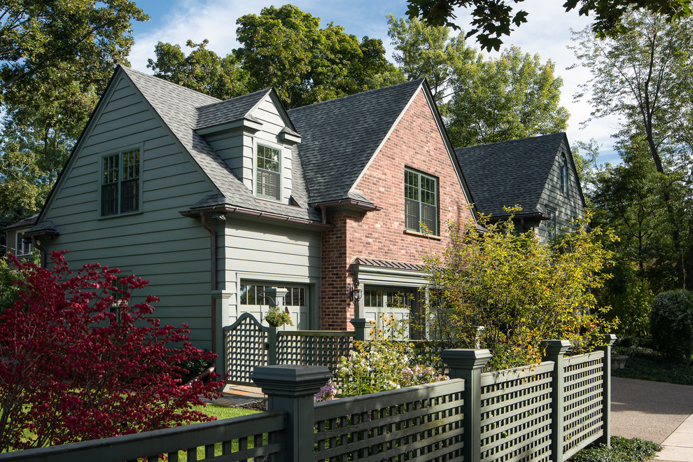 Inspiration for an expansive traditional two-storey green house exterior in Detroit with wood siding, a gable roof and a shingle roof.