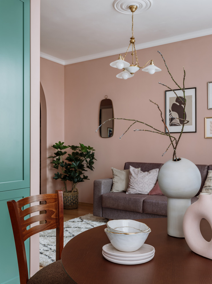 На фото: открытая гостиная комната среднего размера в стиле ретро с розовыми стенами и светлым паркетным полом с