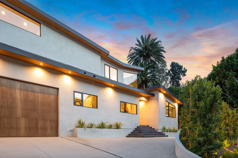 ロサンゼルスにある高級なコンテンポラリースタイルのおしゃれな家の外観 (漆喰サイディング、緑化屋根) の写真